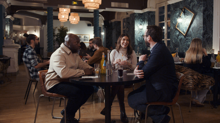 Trois personnes discutant autour d'une table dans le restaurant Villa Maasaï